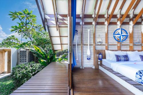 a bedroom with a bed on a balcony at Villa Atra Bambulogy by Nagisa Bali in Kerobokan