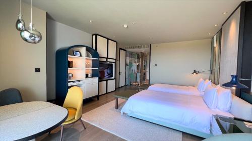 a bedroom with a large bed and a table at New World Hoiana Beach Resort in Hoi An