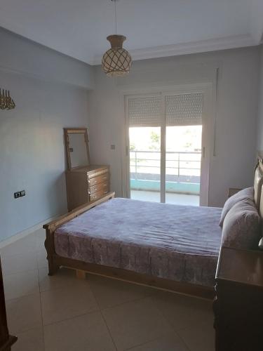 een slaapkamer met een groot bed en een raam bij Appartement des vacances in Tetouan