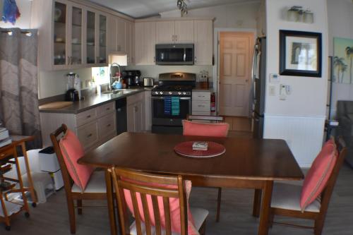 a kitchen with a wooden table and chairs and a kitchen with a refrigerator at Pelican's Roost, Waterfront comfort at Venture Out in Cudjoe Key
