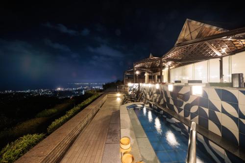 a resort with a swimming pool at night at Beppu SUGINOI HOTEL in Beppu