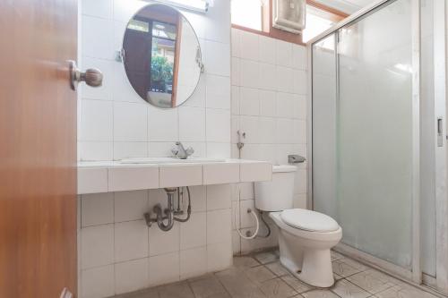La salle de bains est pourvue de toilettes, d'un lavabo et d'un miroir. dans l'établissement Dequr Hotel Dipati Ukur Mitra RedDoorz, à Bandung