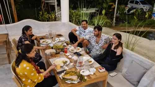 un grupo de personas sentadas alrededor de una mesa comiendo comida en Matsya en Havelock Island