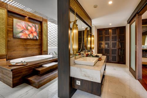 a bathroom with a tub and a sink at The Samaya Ubud in Ubud