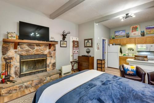 a bedroom with a fireplace and a tv on a wall at Angel Fire Studio with Fireplace, Walk to Resort! in Angel Fire