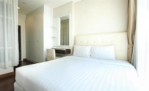 a large white bed in a room with a window at Ivy Thonglor 55 in Bangkok