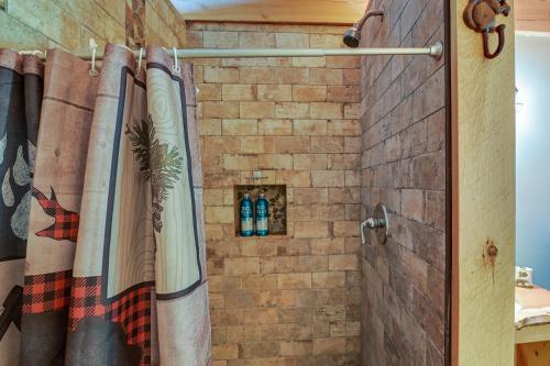 La salle de bains est pourvue d'une douche et d'un mur en briques. dans l'établissement Cozy South Bay Cabin with Lake and Mountain Views, 