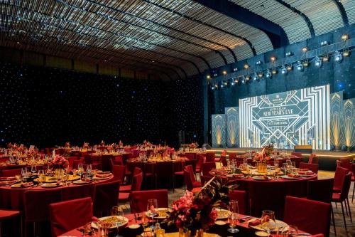 a banquet hall with tables and chairs and a stage at New World Hoiana Beach Resort in Hoi An