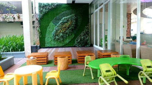 a room with a green table and chairs and a wall at Apartement Bogor Icon Syariah, View Gunung Salak in Bogor