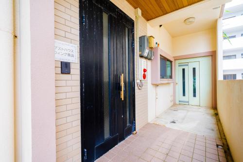 a black door on the side of a building at Wing Mihama in Chatan