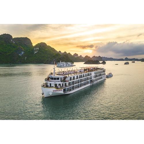 a cruise ship in the water at sunset at Indochine Cruise Lan Ha Bay in Ha Long