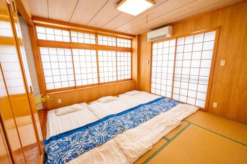 a large bed in a room with two windows at Wing Mihama in Chatan