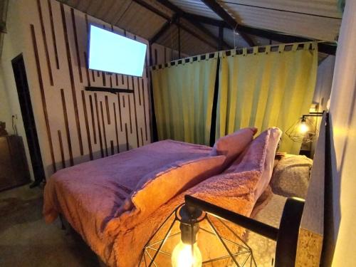 Schlafzimmer mit einem Bett und einem TV an der Wand in der Unterkunft Cabaña De Ian (Deluxe) in San Antonio del Tequendama