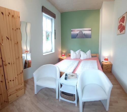 1 dormitorio con 1 cama con 2 sillas y 1 mesa en Alte Forsterei, en Altenbrak