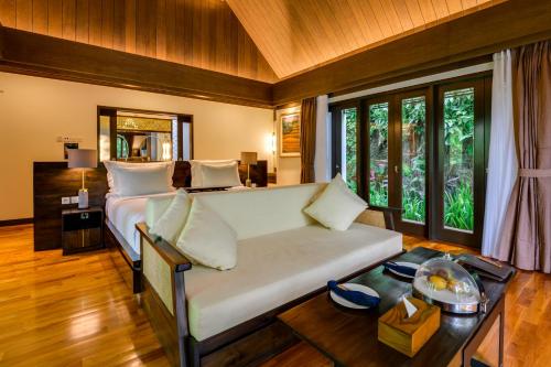 a bedroom with a bed in a room with windows at The Samaya Ubud in Ubud