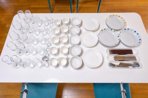 a white table with plates and utensils on it at Wing Mihama in Chatan