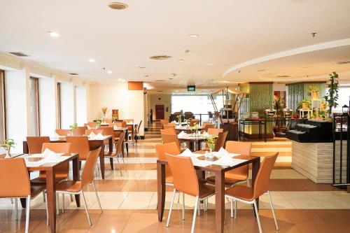 a restaurant with tables and chairs in a room at AP Premier Batam in Nagoya