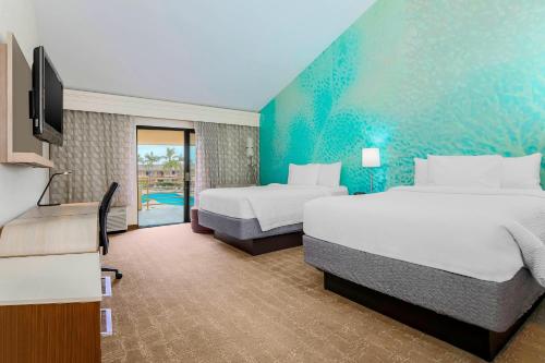 a hotel room with two beds and a television at Courtyard by Marriott San Diego Del Mar/Solana Beach in Solana Beach