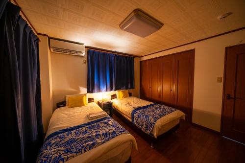 a hotel room with two beds and a window at Wing Mihama in Chatan