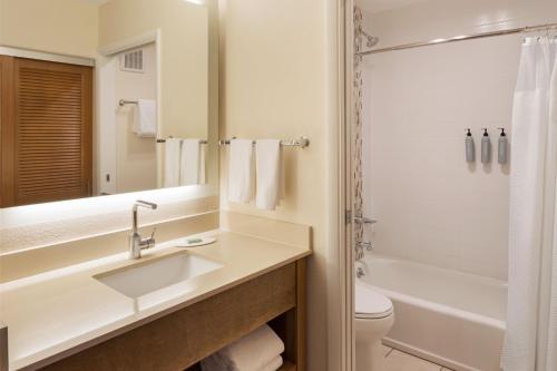 a bathroom with a sink and a tub and a toilet at Courtyard by Marriott San Diego Del Mar/Solana Beach in Solana Beach