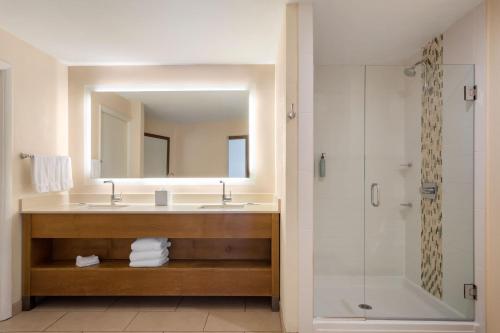a bathroom with a sink and a mirror and a shower at Courtyard by Marriott San Diego Del Mar/Solana Beach in Solana Beach