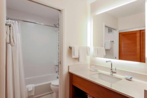 a bathroom with a sink and a shower and a toilet at Courtyard by Marriott San Diego Del Mar/Solana Beach in Solana Beach