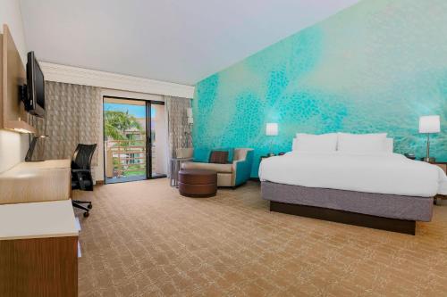 a large hotel room with a bed and a couch at Courtyard by Marriott San Diego Del Mar/Solana Beach in Solana Beach