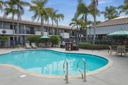 a swimming pool at a resort with palm trees at Courtyard by Marriott San Diego Del Mar/Solana Beach in Solana Beach