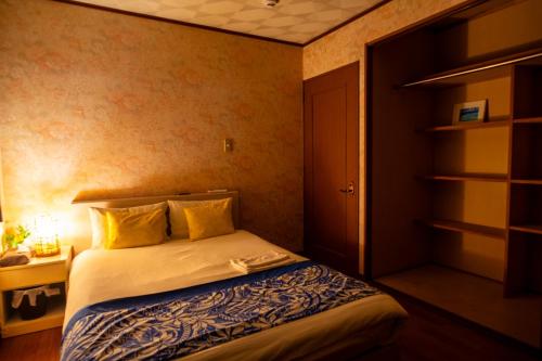 a bedroom with a bed with yellow pillows at Wing Mihama in Chatan