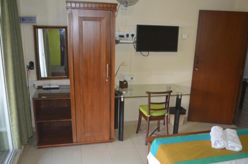 Un dormitorio con una cama y un escritorio con una mesa. en Paramount Residence 3, en Kelaniya