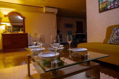 a table with wine glasses on it in a living room at Wing Mihama in Chatan