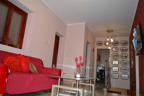 sala de estar con sofá rojo y mesa de cristal en Casa CORAZON DE LEÓN AQP en Arequipa