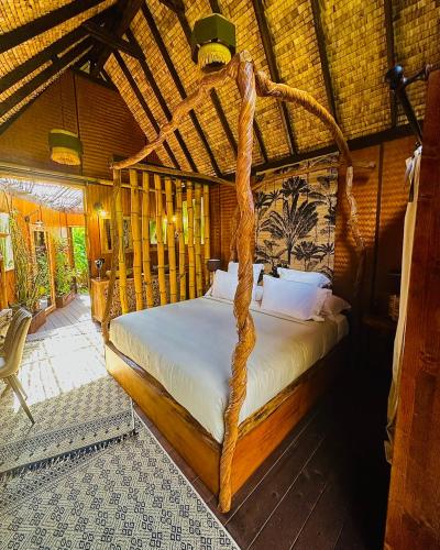 a bedroom with a bed with a wooden frame at Hôtel Fenua Mata'i'oa in Papetoai