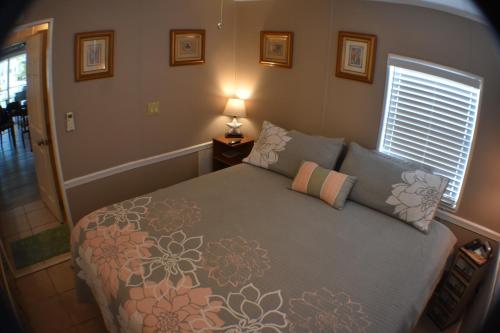 a bedroom with a bed and a lamp and a window at Pelican's Roost, Waterfront comfort at Venture Out in Cudjoe Key