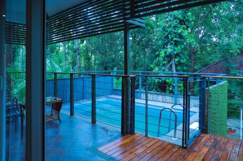 a balcony with a view of a swimming pool at Kuruva Island Resort And Spa - By KABINI BREEZE in Mananthavady