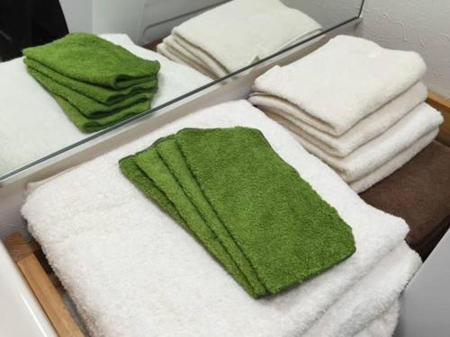 東京にあるCheese Cozy Condoのバスルームの棚にタオルを積み重ねる