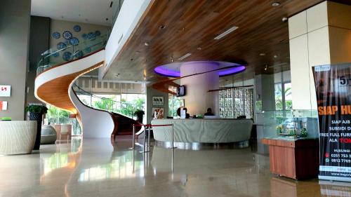 a lobby with a spiral staircase in a building at Apartement Bogor Icon, View Gunung Salak in Bogor