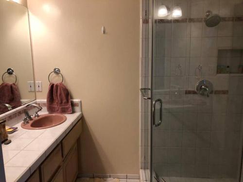 ein Bad mit einer Glasdusche und einem Waschbecken in der Unterkunft Centrally located 4 bd/2.5 ba house in Cupertino in Cupertino