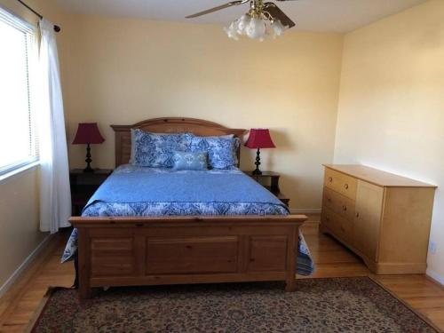 Schlafzimmer mit einem Bett mit blauer Bettwäsche und einer Kommode in der Unterkunft Centrally located 4 bd/2.5 ba house in Cupertino in Cupertino