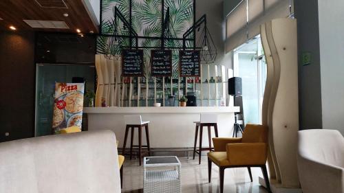 a bar in a restaurant with chairs and a counter at Apartement Bogor Icon, View Gunung Salak in Bogor