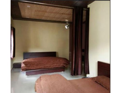 een slaapkamer met een bed en een raam bij Green Heaven Resort , Chakrata in Chakrata