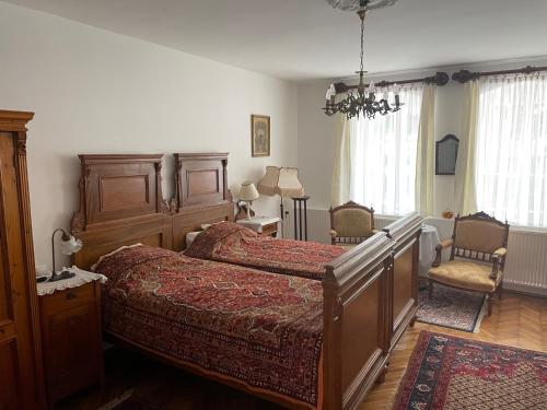 a bedroom with a large bed and two chairs at Hajós-ház in Szeged