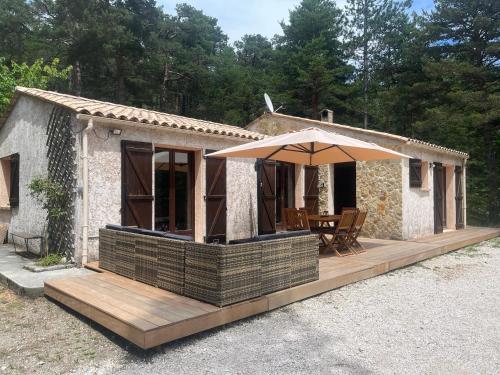 Casa pequeña con sombrilla y terraza de madera en Les rocailles, en Valderoure