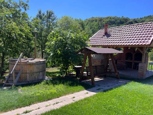 cenador de madera y bañera de hidromasaje en un patio en Pensiunea La Buru, en Căraciu