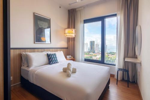 a bedroom with a large bed with a large window at Tropicana 218 X Airlevate Suites in George Town