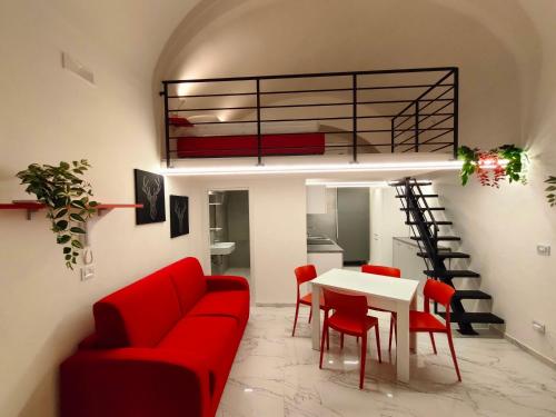 a living room with a red couch and a table at La Disfida Di Barletta in Barletta