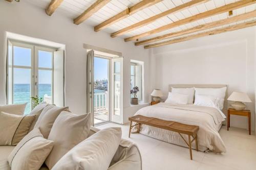 Un dormitorio blanco con una cama y un sofá. en Fotis House - Unique in Paros, en Naousa