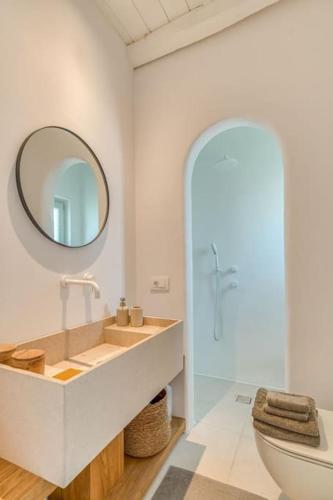 a bathroom with a sink and a mirror and a toilet at Fotis House - Unique in Paros in Naousa