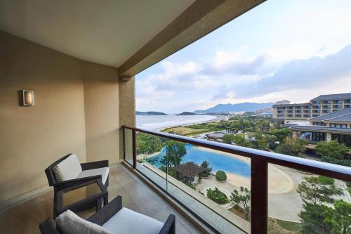 a balcony with chairs and a view of the ocean at The Westin Zhujiajian Resort, Zhoushan in Zhoushan