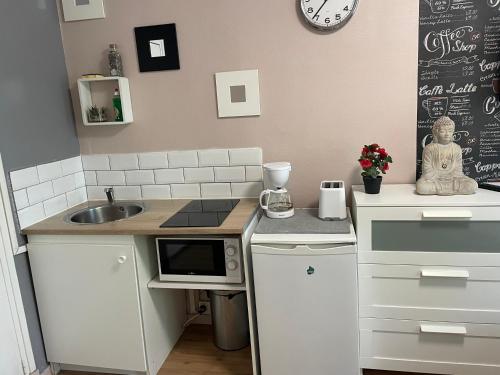 a small kitchen with a sink and a microwave at Studio Montsouris in Paris